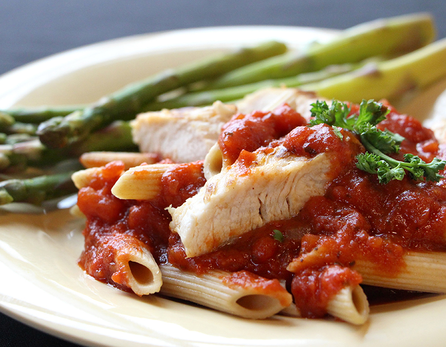 Whole wheat pasta with tomato sauce, chicken, and asparagus.