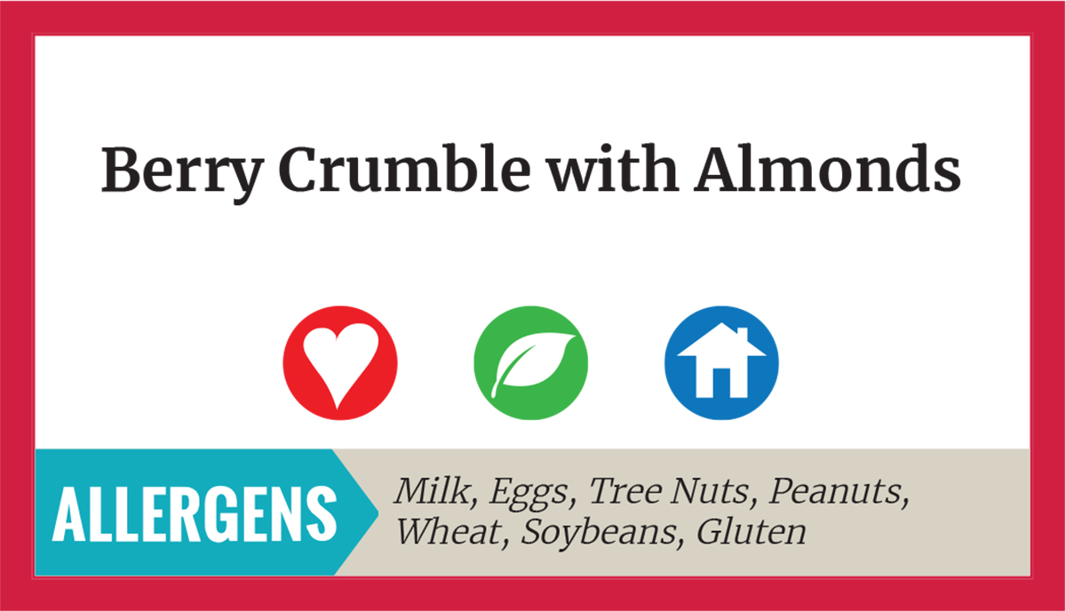 A menu tag reading Berry Crumble with Almonds with three icons: red with a heart for heart healthy, yellow with a V for vegan, and blue with a house for Taste of Home. Text at the bottom reading: Allergens: Milk, Eggs, Tree Nuts, Peanuts, Wheat, Soybeans, Gluten