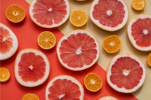 Image of grapefruit and oranges against a yellow and orange background.