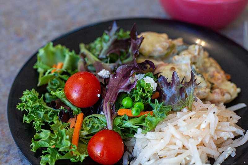 Image of a leafy green salad with rice and another side made at a UGA dining hall.