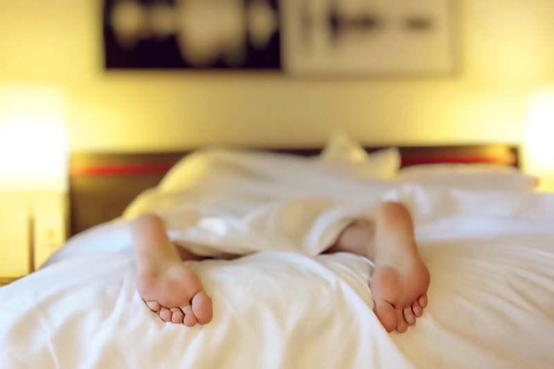 Image of a person's feet while they lay down in a bed.