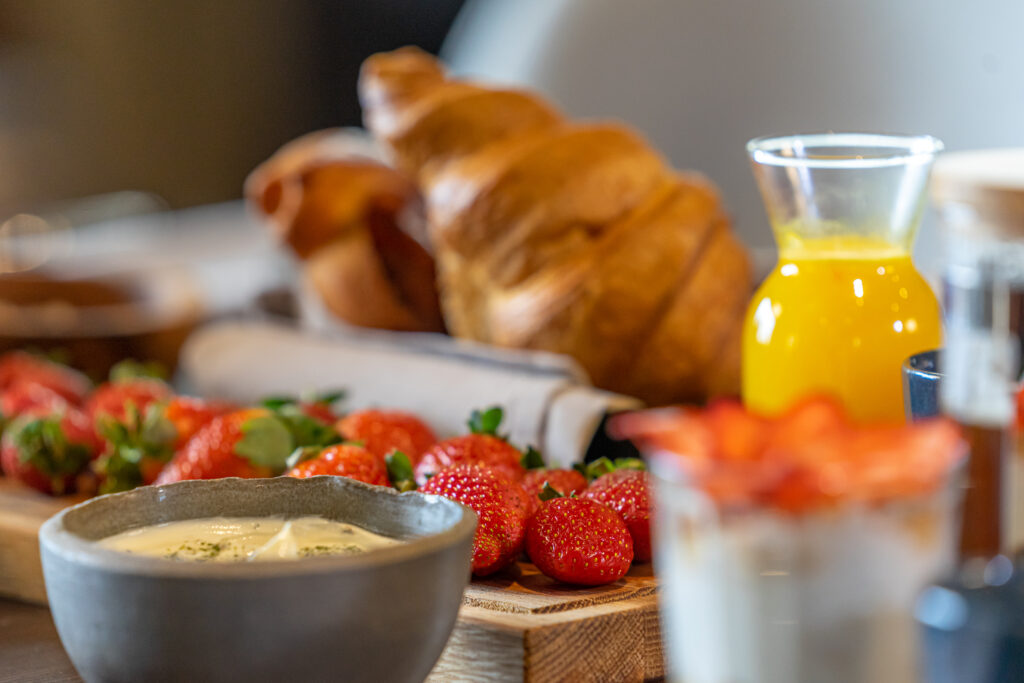 Breakfast served with coffee, orange juice, croissants, cereals and fruits.