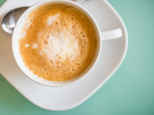 Hot latte coffee from top view on pastel blue background