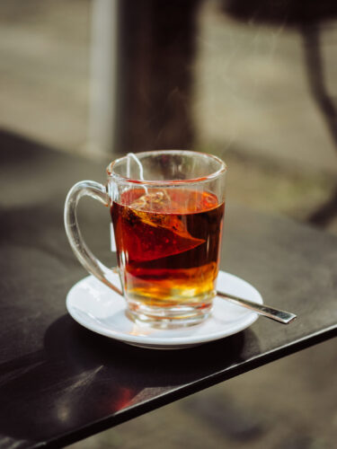 a clear mug of hot tea on a table