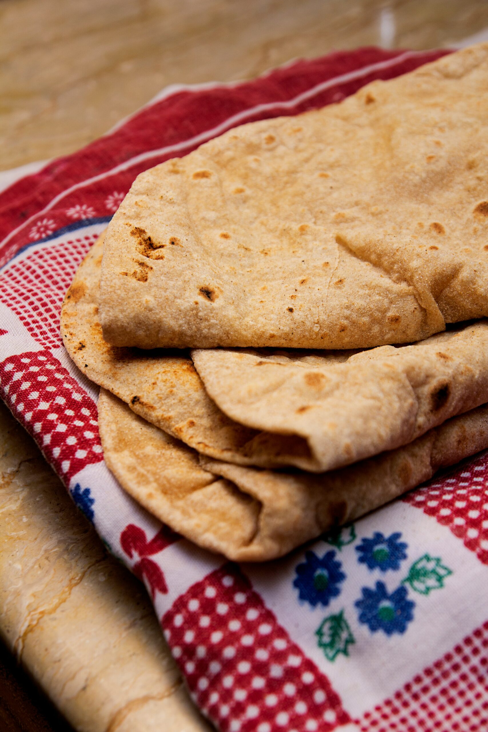 whole grain tortillas laying on a red and white napkin. 